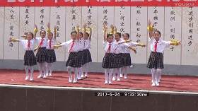 小学女生们在台上给下面的同学们表演精彩节目